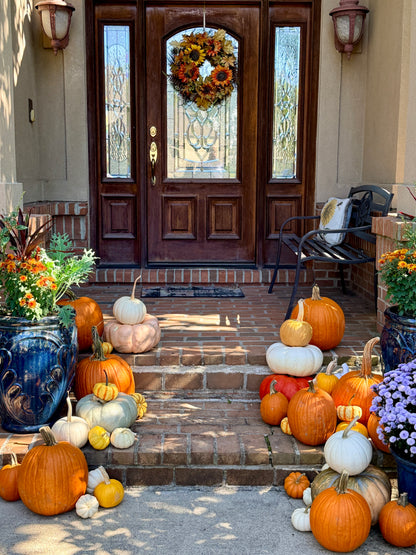 Front porch with pumpkins, flowers, and a wreath on a wooden door. fairy dust and rust 