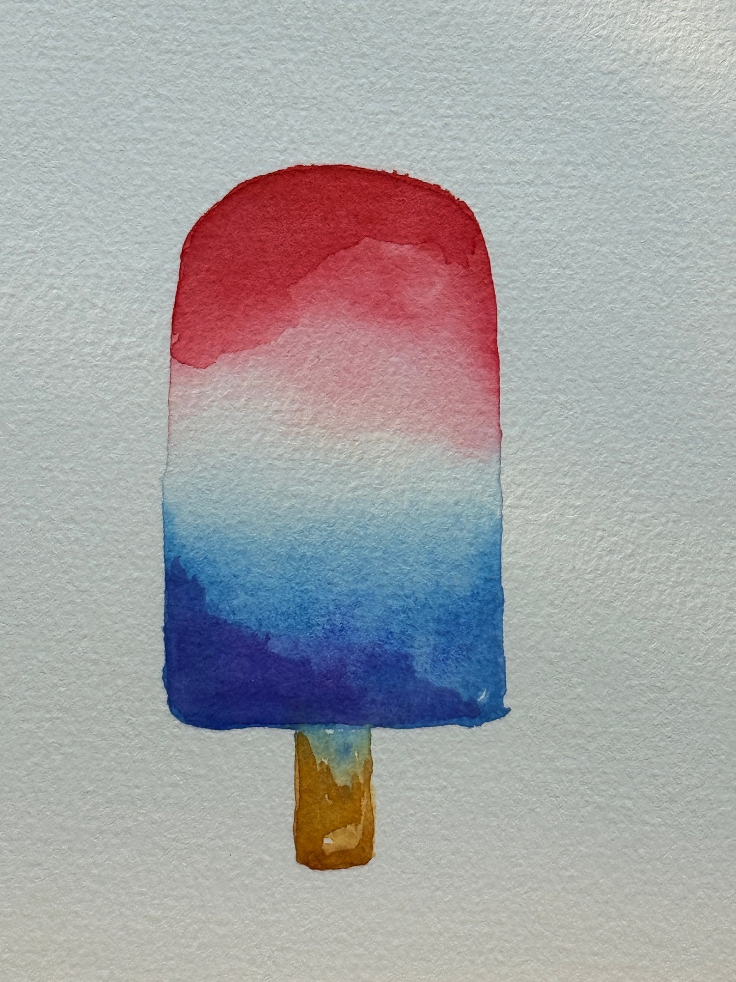 Watercolor painting of a red, white, and blue popsicle on a light gray background