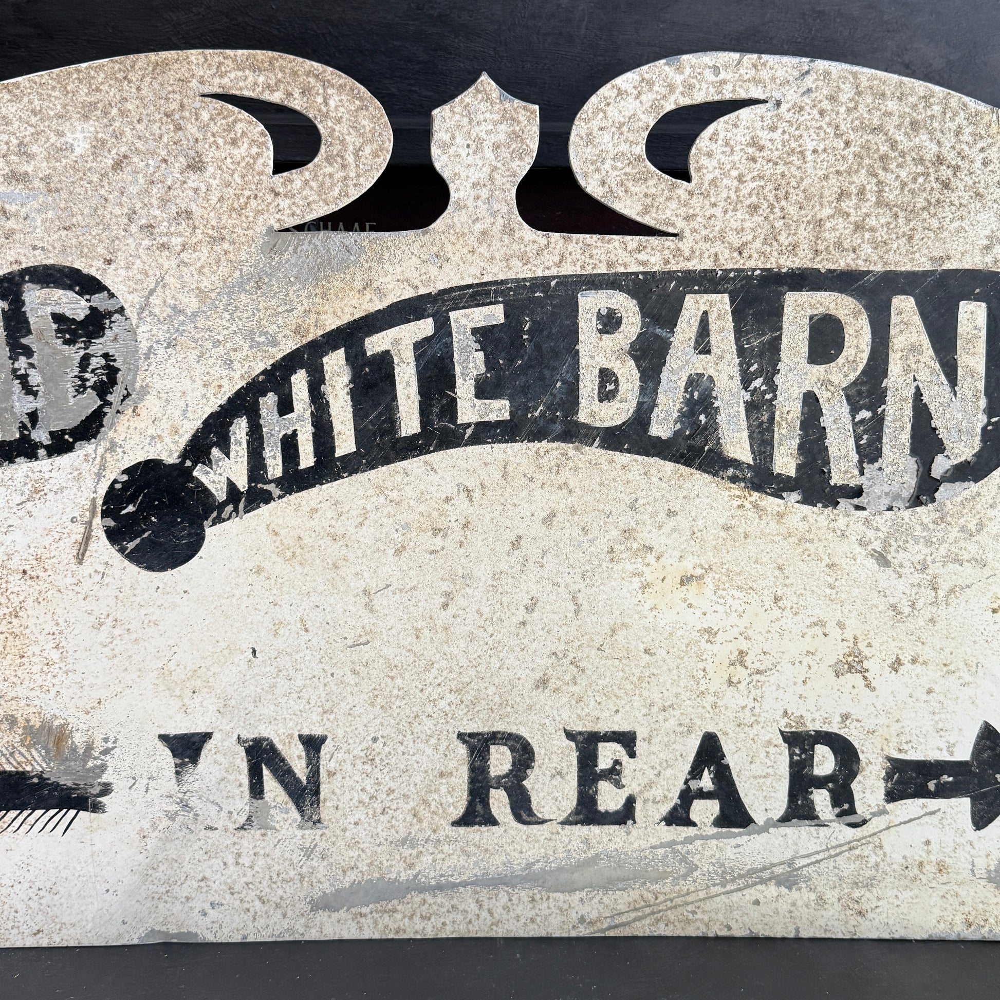 Vintage-style sign with 'White Barn' text on a textured background